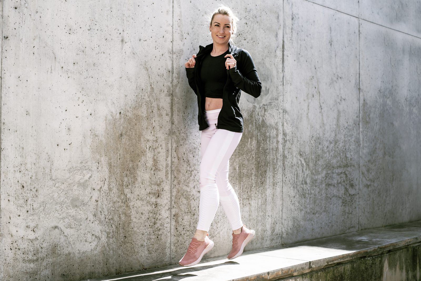 Nikola Bartáková ve sportovním oblečení opřená o betonovou zeď